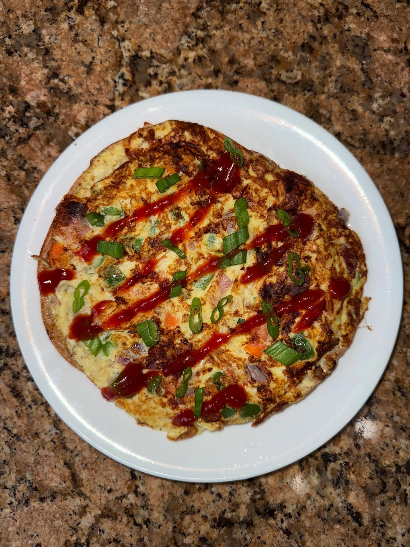 onion, bell pepper, carrot, garlic, scallion omelette with chaat masala on a tor