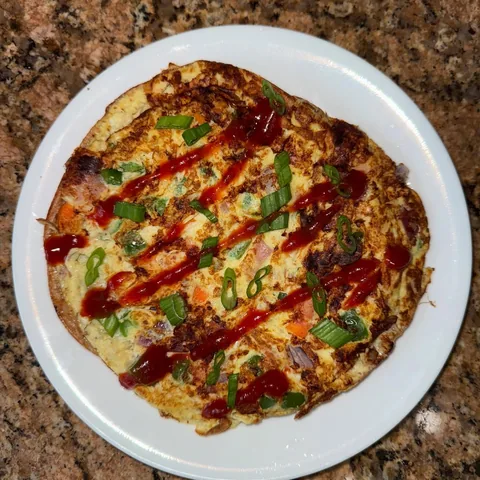 onion, bell pepper, carrot, garlic, scallion omelette with chaat masala on a tor